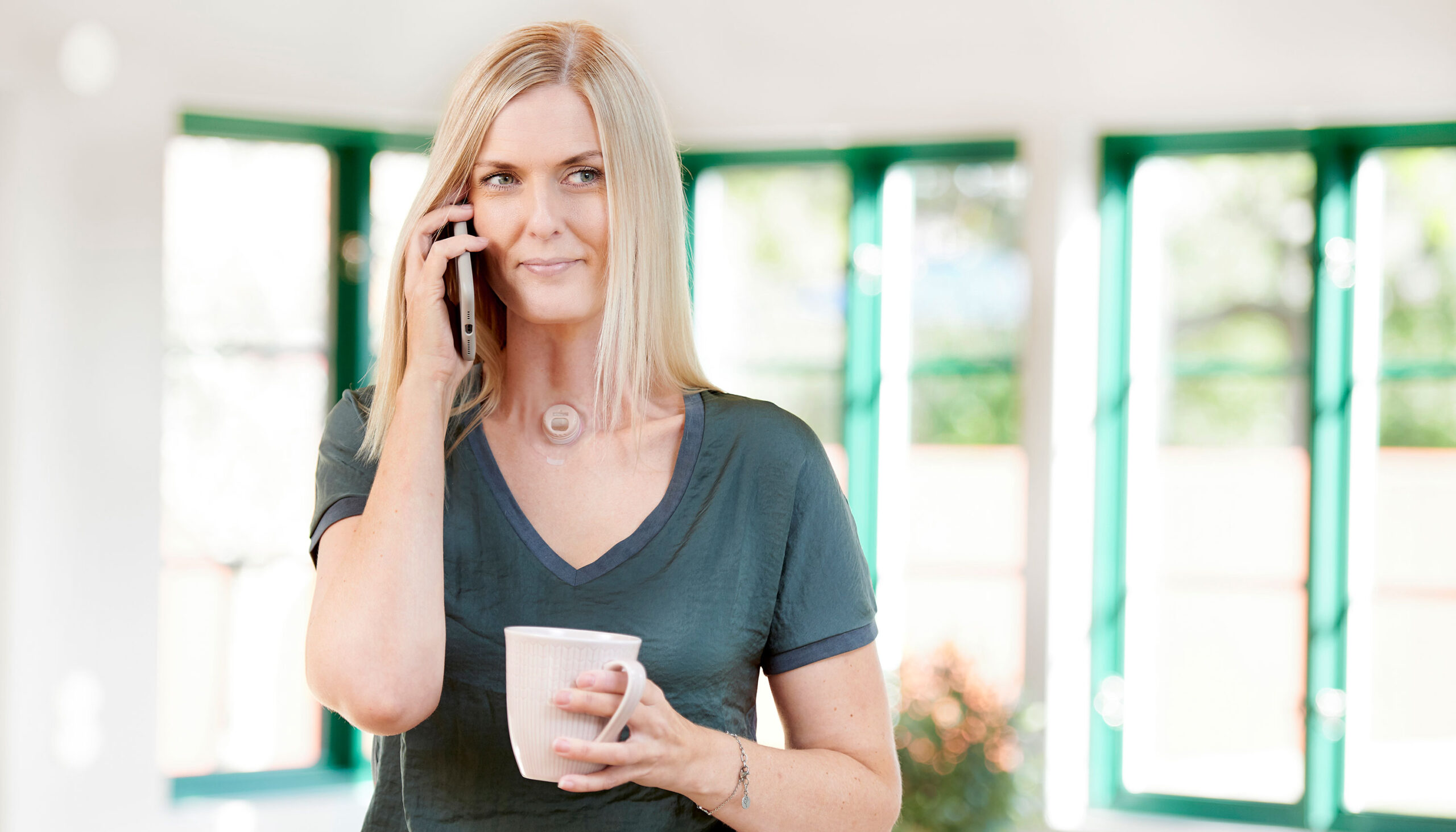 woman using provox life freehands hme while talking on phone indoors